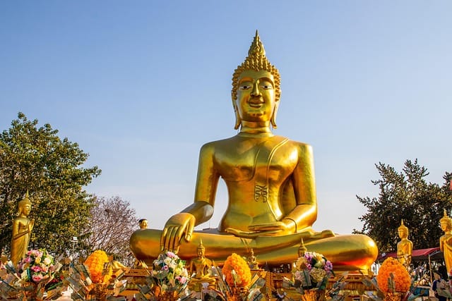 Golden Buddha statue in Pattaya Thailand with sunlight reflecting on intricate details