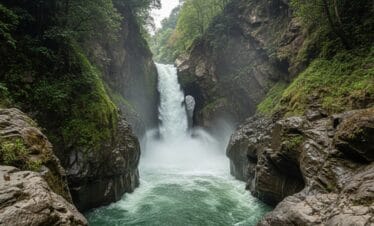 Wide-angle shot of Davis Falls (Patale Chhango) in Pokhara Nepal showing powerful waterfall and mist rising from gorge